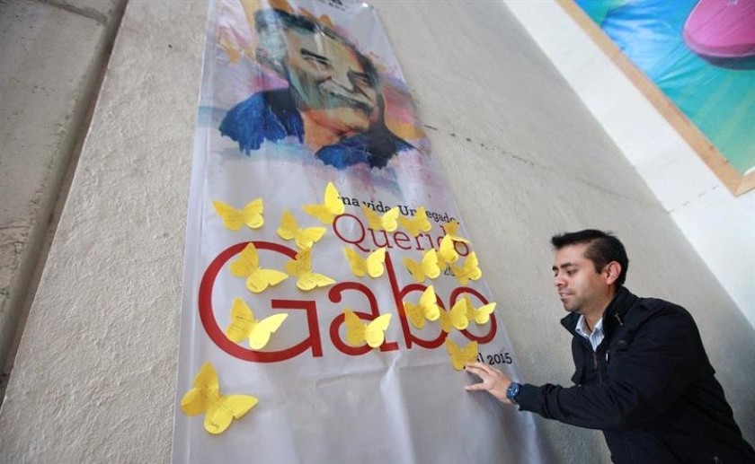 Un empleado de una librería en ciudad de México coloca mariposas de papel amarillo en un mural. Foto: EFE