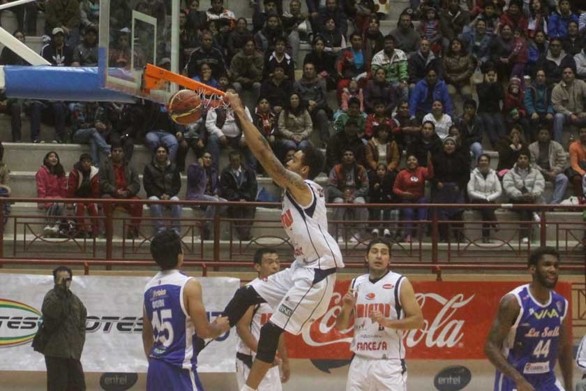 El jugador norteamericano de Amistad, Fred Woods (i), anota dos puntos en el partido, frente a La Salle de Tarija