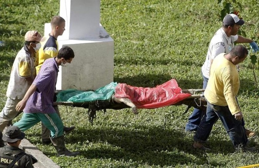 Habitantes y rescatistas cargan el cuerpo de una víctima de una riada ocasionada por la quebrada Liborina. Foto: EFE