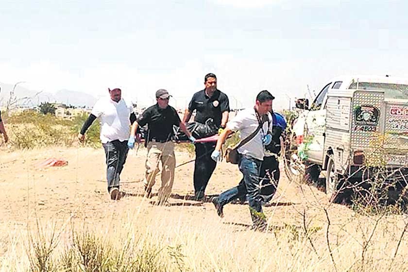 ASESINATO. Forenses mexicanos trasladan el cuerpo de Christopher Raymundo tras ser encontrado muerto en un descampado.