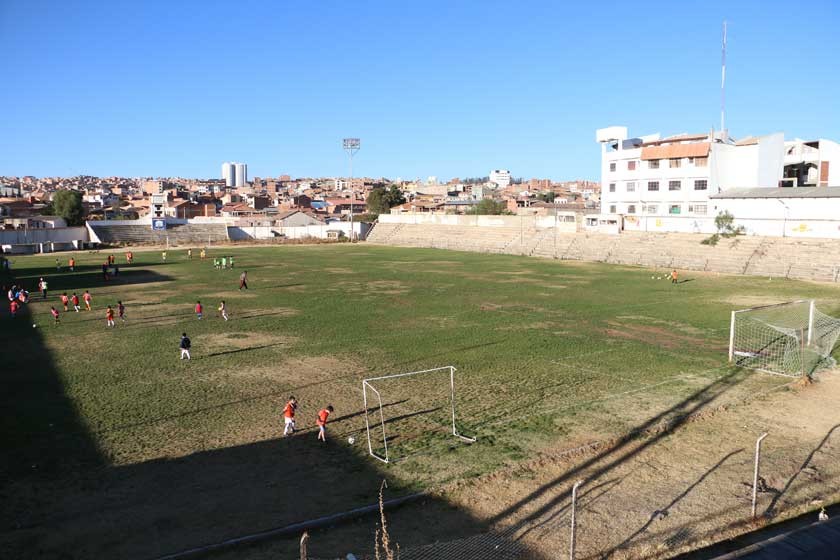 Un césped imperfecto y olvidado del estadio Sucre es el escenario para que niños de algunas escuelas de fútbol realicen