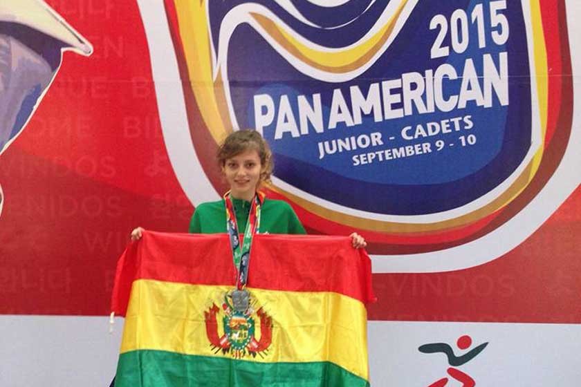 La deportista nacional Ana Mogro, posa junto a la bandera boliviana y la medalla de plata del Panamericano.