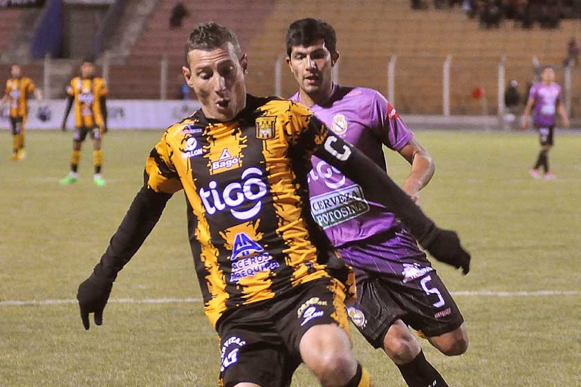Pablo Escobar protege el balón ante la marca de un jugador de Real Potosí anoche, en la Villa Imperial.