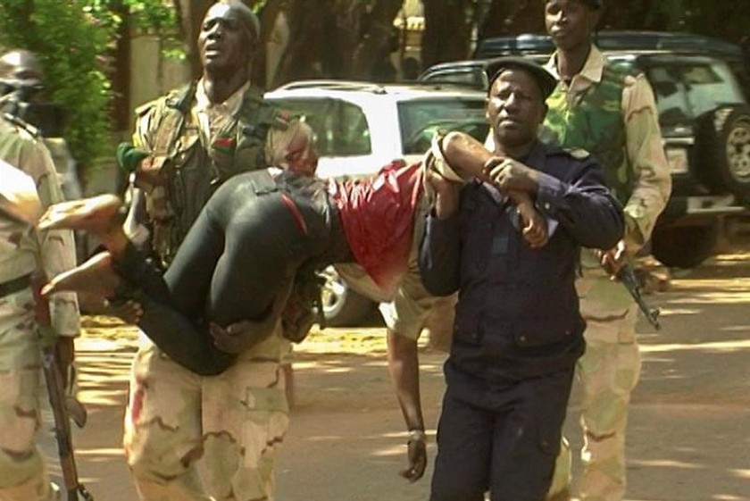 Personal militar de Mali traslada a una mujer herida a su salida del hotel de lujo Radisson Blu en Bamako. EFE