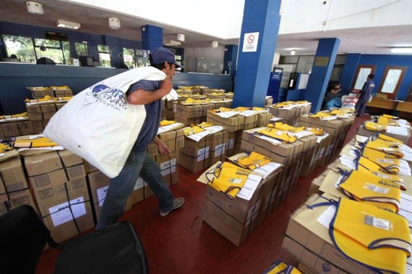 Un empleado de Correos carga urnas electorales para ser repartidas en los colegios de votación. Foto: EFE