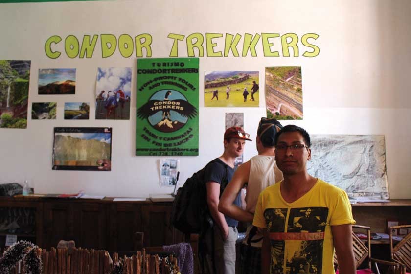 Alan Condori y, atrás, dos turistas extranjeros, en la agencia de viajes ubicada en pleno centro de Sucre.