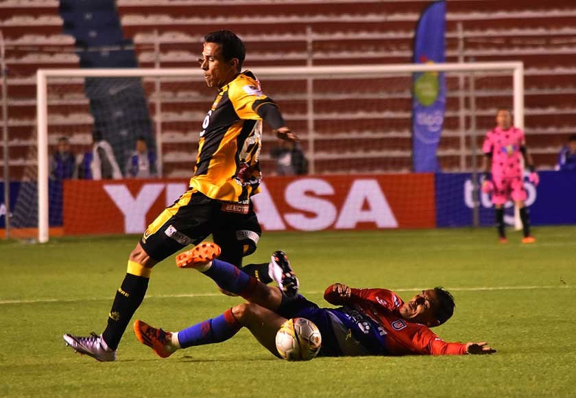 El estudiantil Alexis Bravo se barre al piso en el partido de anoche, frente a The Strongest, en La Paz.