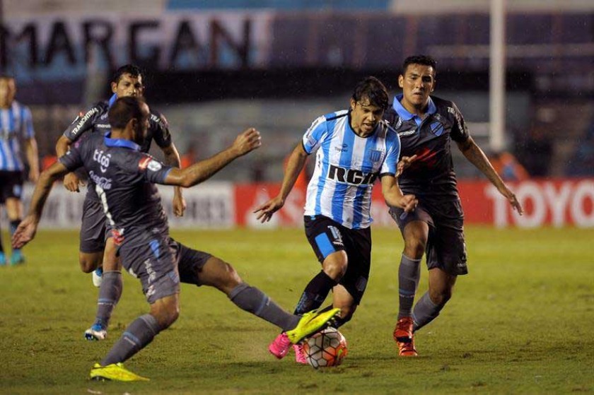 La defensa de la academia paceña intenta frenar a un jugador de Racing, en el partido jugado anoche, en Argentina.