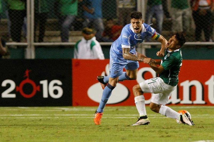 El defensor académico Nelson Cabrera (i) disputa el balón ante el colombiano Andrés Roa en el partido jugado anoche