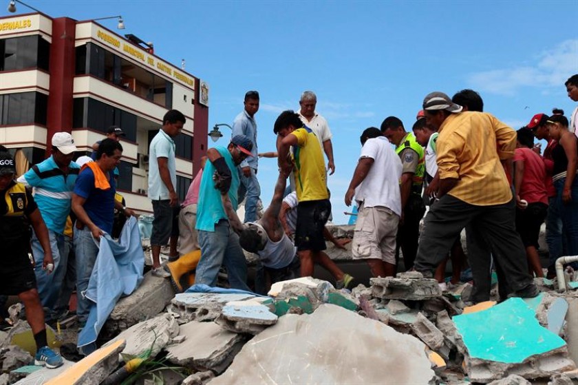 Pobladores rescatan un cuerpo entre los escombros en la localidad de Pedernales en Ecuador. FOTO: EFE