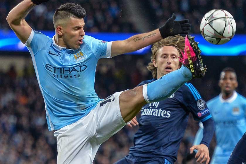 Sergio Agüero del Manchester City pretende controlar el balón ante la presencia de Luka Modric del Madrid.