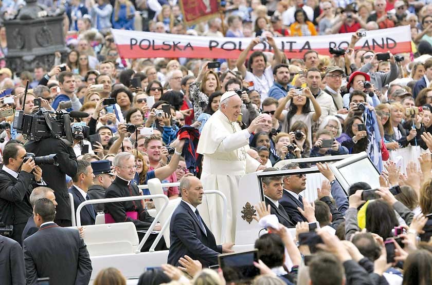 SALUDO. El papa Francisco saluda a los fieles a su llegada a la audiencia semanal en la Plaza de San Pedro.