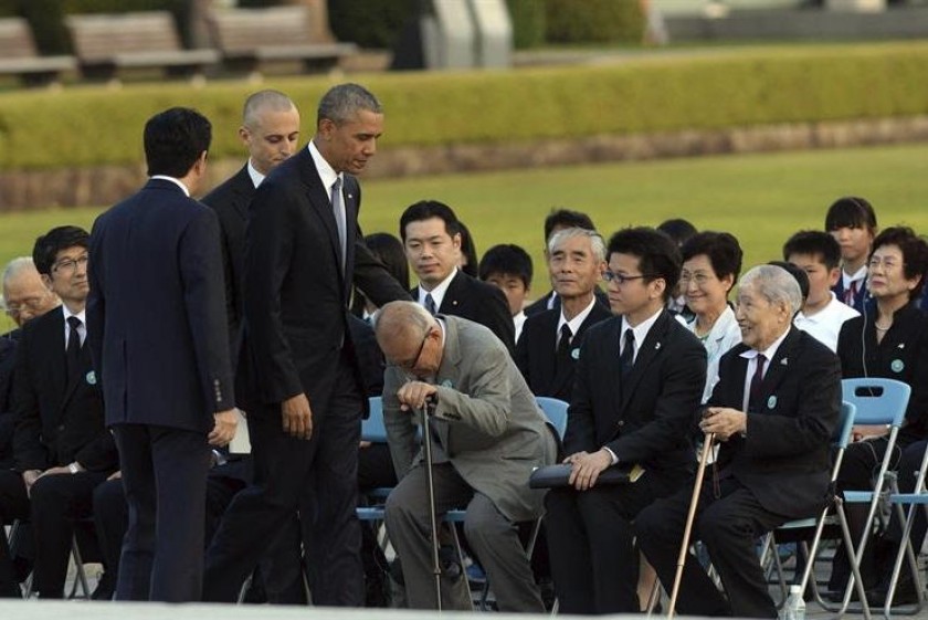 Barack Obama (c), y el primer ministro nipón, Shinzo Abe (i), asisten a una ofrenda floral en el Parque de la Paz. EFE