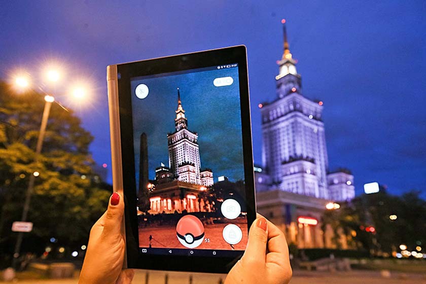 JUEGOS. Una joven juega con la aplicación Pokémon Go cerca al Palacio de la Ciencia y la Cultura de Varsovia