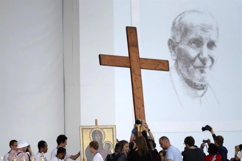 Varios peregrinos sostienen una cruz de madera durante la santa misa inaugural de la XXXI JMJ. Foto: EFE