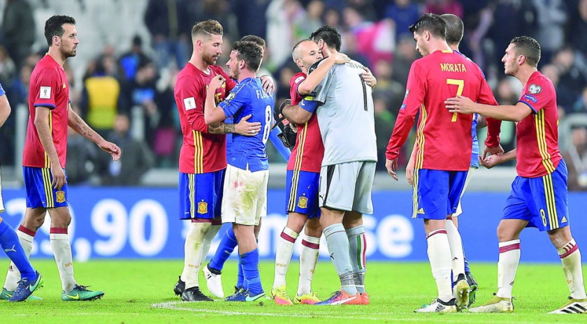 Los jugadores italianos y españoles se abrazan al final del partido que sus selecciones empataron por las eliminatorias