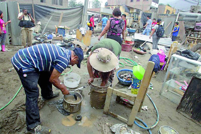 ESCOMBROS. Damnificados buscan sus pertenencias entre los escombros que dejó una inundación en Tarazona, cerca de Lima.