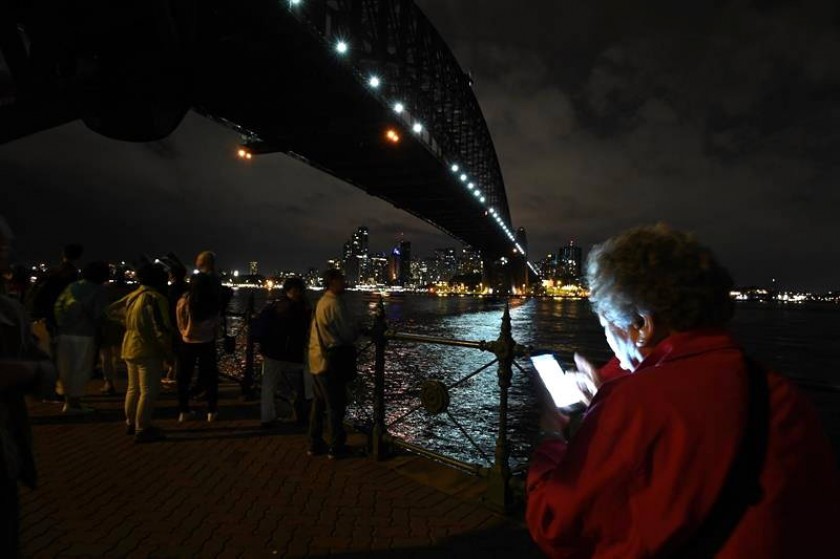 La gente se reúne para mirar el horizonte de Sydney de Milsons Point durante la Hora del Planeta. Foto: EFE