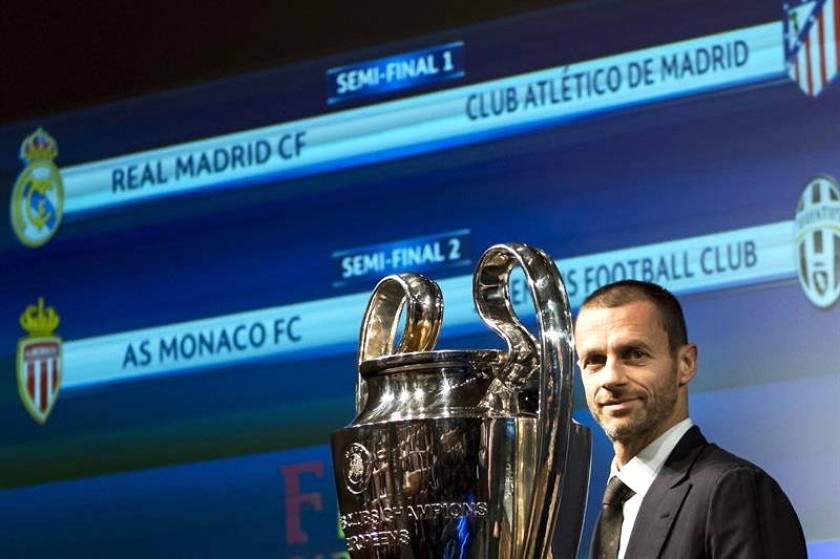 Presidente de la UEFA, Aleksander Ceferin, posa junto al trofeo de la Champions con el resultado del sorteo de fondo.