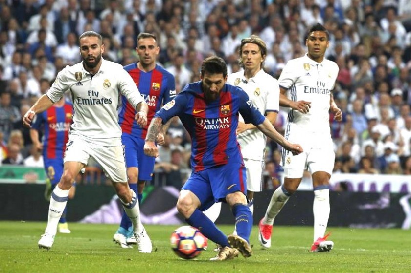 Leo Messi se dispone a golpear el balón ante los defensores del Real Madrid, consiguiendo el primer gol para su equipo.