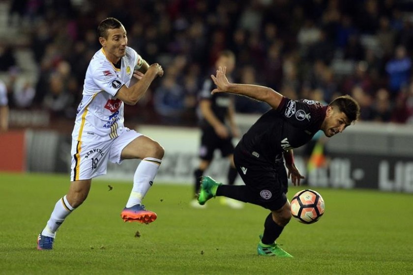 Pablo Escobar de The Strongest disputa el balón con Diego Braghieri de Lanús. Foto: EFE