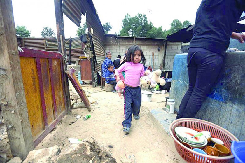 DAÑOS. Una niña recoge sus muñecas en el lugar donde estaba la sala de su casa, afectada por el terremoto.