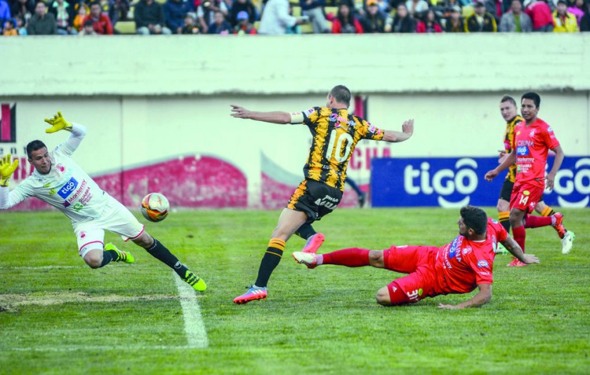 El capitán atigrado Pablo Escobar (c) remate el balón al arco azucarero ante la marca de un defensor montereño.