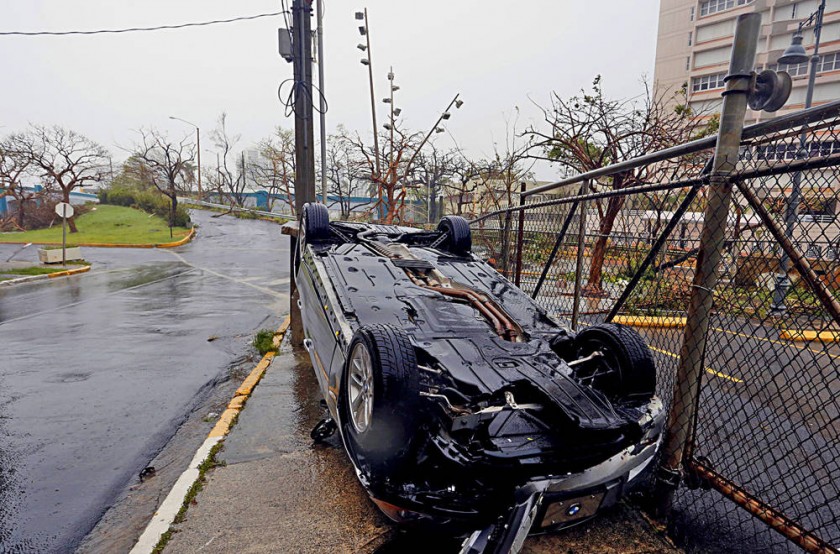 FEROZ. Vista de un automóvil volcado tras el paso del huracán María en un barrio de San Juan, capital de Puerto Rico.
