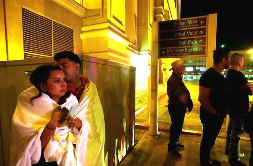 Varias personas permanecen a la entrada del hotel Mandalay Bay, cerca del lugar donde se produjo un tiroteo. EFE