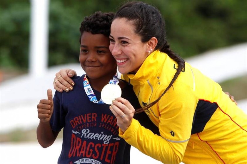 La colombiana Mariana Pajón (d) posa con un aficionado durante la premiación de la prueba rueda de 20 pulgadas femenina