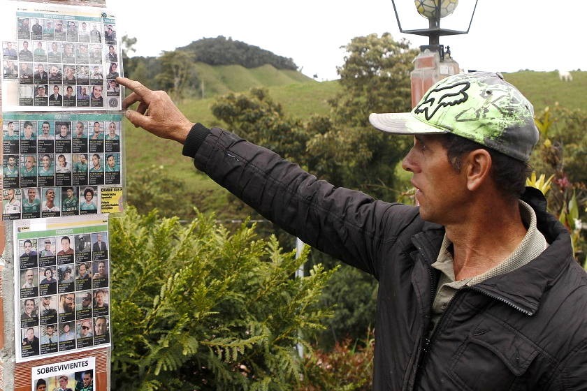 Luis Albeiro Valencia señala fotografías de las víctimas de la tragedia ayer, lunes, en el Cerro Gordo. EFE