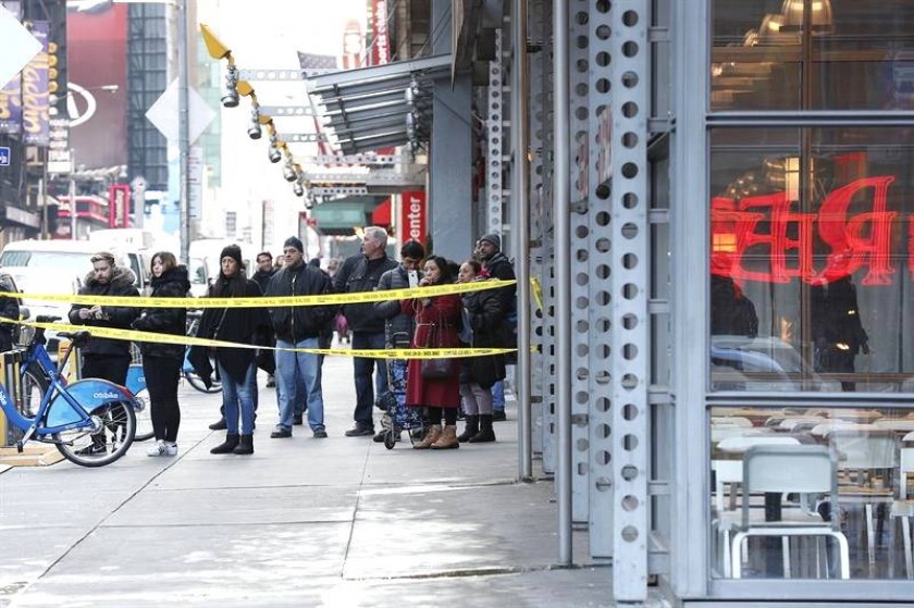 Curiosos observan desde el cordón policial ante la terminal de autobuses de la Autoridad del Puerto en Nueva York. EFE