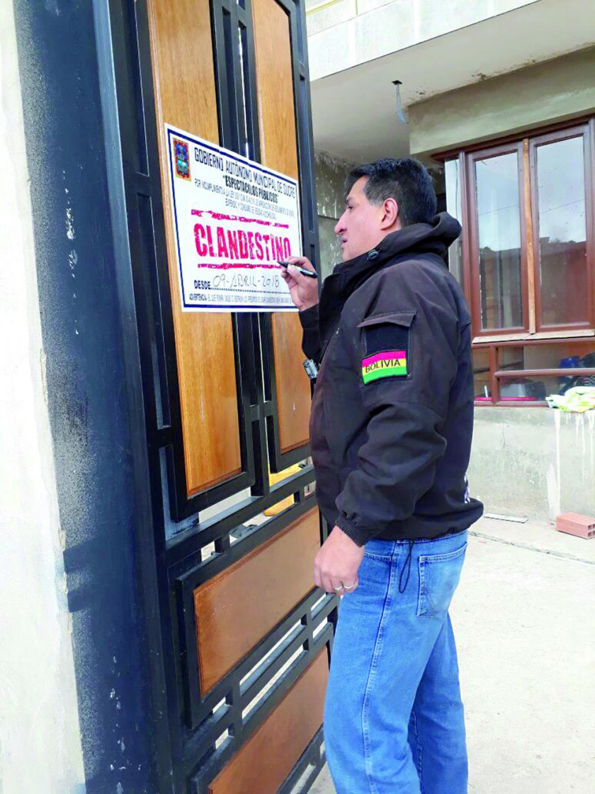 SANCIÓN. Un funcionario municipal coloca el precinto de seguridad para clausurar unos de los dos lenocinios encontrados