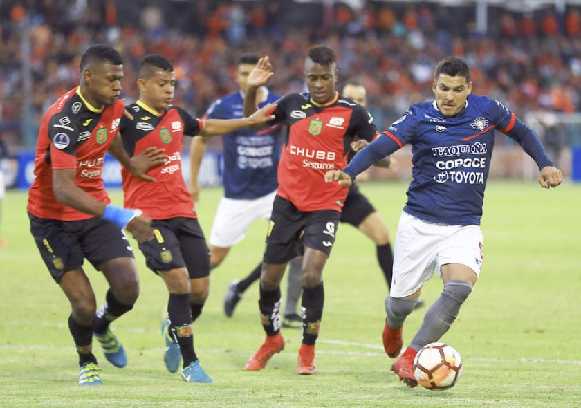 El volante aviador Cristian Chávez resiste la marca de sus rivales del Deportivo Cuencia, durante el partido...