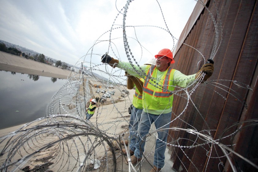 PREVISIÓN. Trabajadores norteamericanos colocan alambre de púas a lo largo del río Tijuana, en la frontera con México.