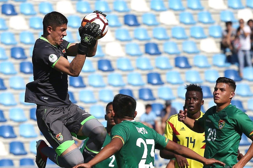 El arquero Jhon Cuellar (i) de Bolivia atrapa un balón en el partido de fútbol frente a Colombia. EFE