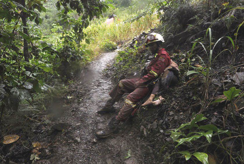 Un bombero lleva el cuerpo de una niña fallecida en el deslizamiento en Caranavi (La Paz). FOTO: APG
