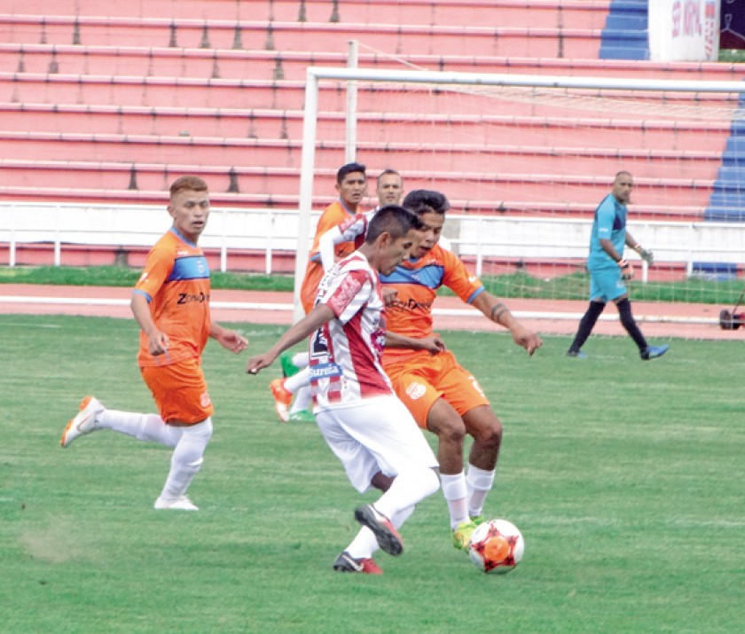 Lateral albirrojo Carlos Balcera intenta escapar ante la marca de un rival.