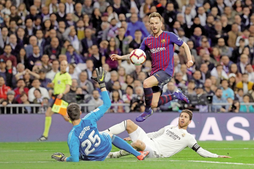El centrocampista croata del FC Barcelona Ivan Rakitic supera la marca de Sergio Ramos para el primer gol.
