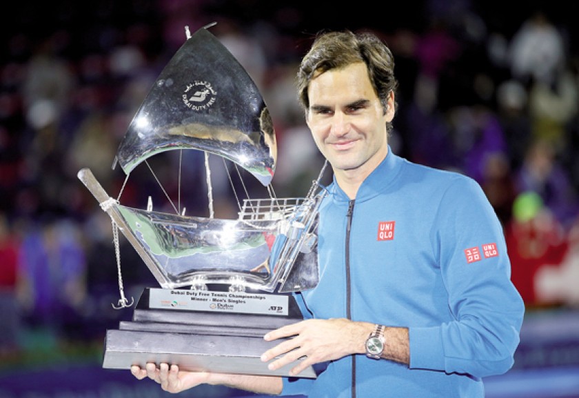 Roger Federer posa junto a su trofeo número 100, conseguido en Dubai.