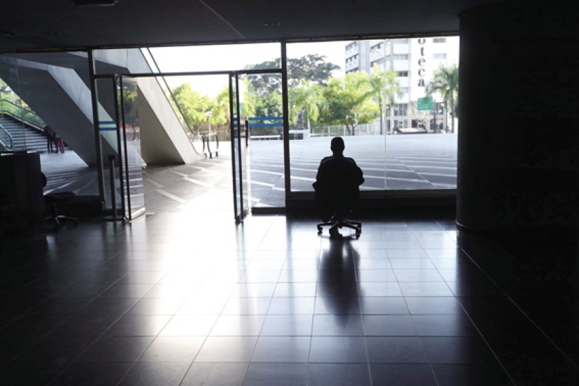 DRAMA. Un hombre mira por la ventana en una oficina sin luz, el pasado sábado, en Caracas (Venezuela).