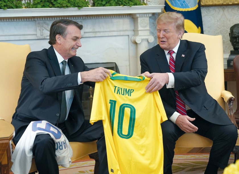 CUMBRE. Donald Trump recibe una camiseta oficial de la selección de fútbol de Brasil durante su reunión con Bolsonaro.