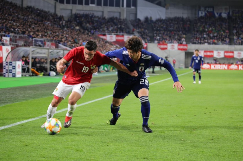 El delantero nacional Leonardo Vaca intenta escapar de la marca de un rival japonés. Foto: Prensa FBF