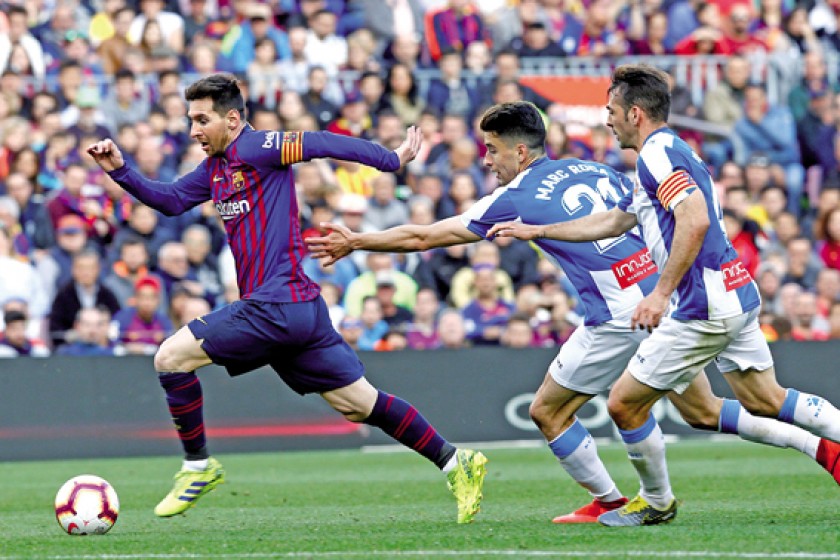 Messi escapa de Marc Roca y Víctor Sánchez, ambos del RCD Espanyol, durante su choque en el Camp Nou.