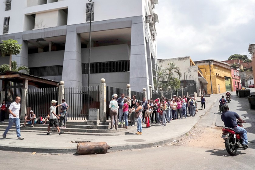 ESCASEZ. Un grupo de personas hace fila para ingresar a un supermercado, en el centro de Caracas.
