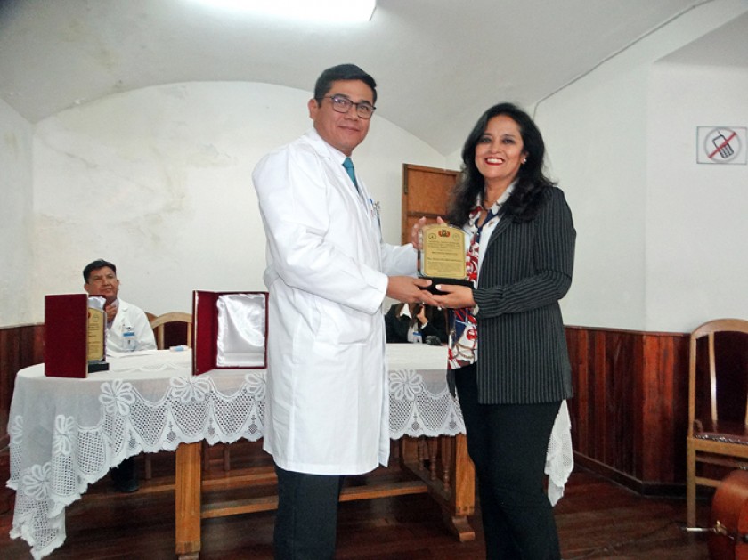 Enrique Leaño hace entrega del reconocimiento a Diana Duchén.