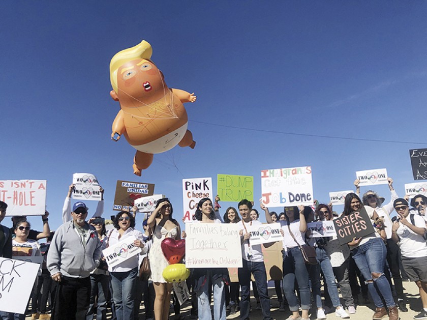 GLOBO. "Bebé Trump" flota sobre un grupo de manifestantes, ayer, en Calexico, California, durante la visita de Trump a l