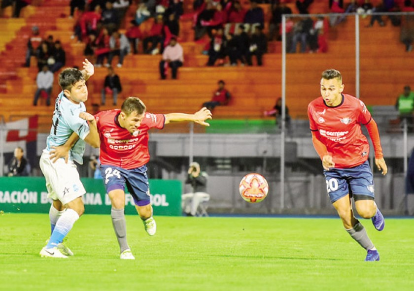 El aviador Oscar Vaca (2i) protege el balón de un rival celeste en el clásico cochabambino disputado ayer