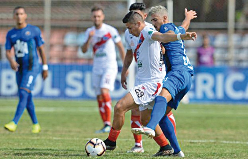 Vladimir Castellón (c) protege el balón ante la marca de un rival venezolano ayer, en el partido por la Copa Sudamerican