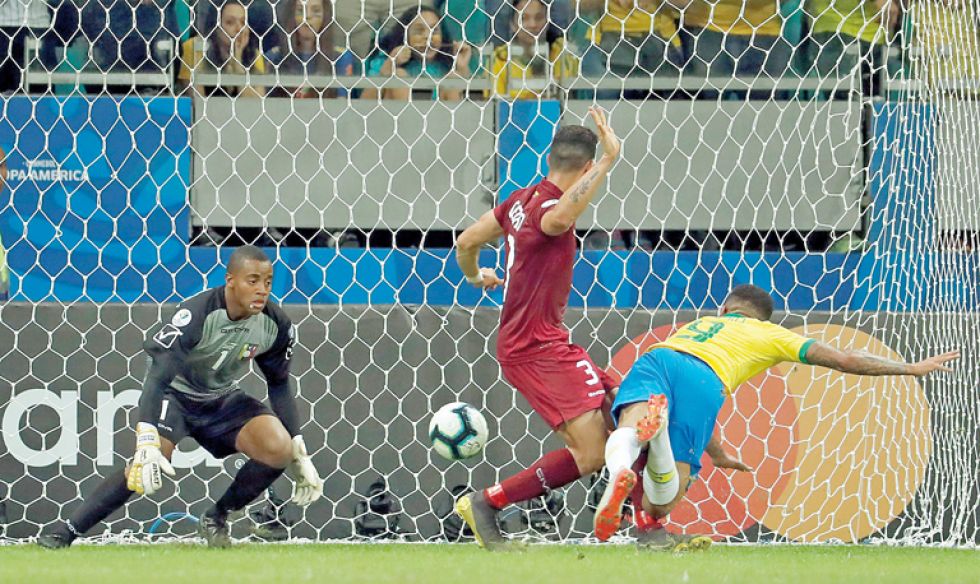 El brasileño Roberto Firmino (i) disputa el balón con Yeferson Soteldo; al lado, el delantero Gabriel Jesús (d) cabecea hacia el arco venezolano.